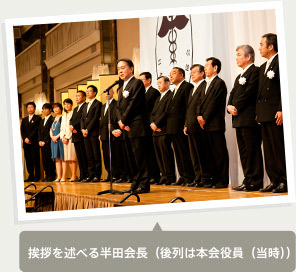 挨拶を述べる半田会長（後列は本会役員（当時））