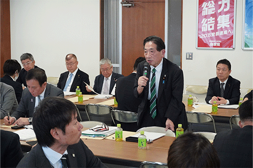 議員発言を聞く佐々木嘉光副会長（手前）と小川克巳議員（奥中央）